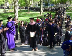 Faculty marshals begin leading the graduates through the lines of faculty and through Kauke Arch