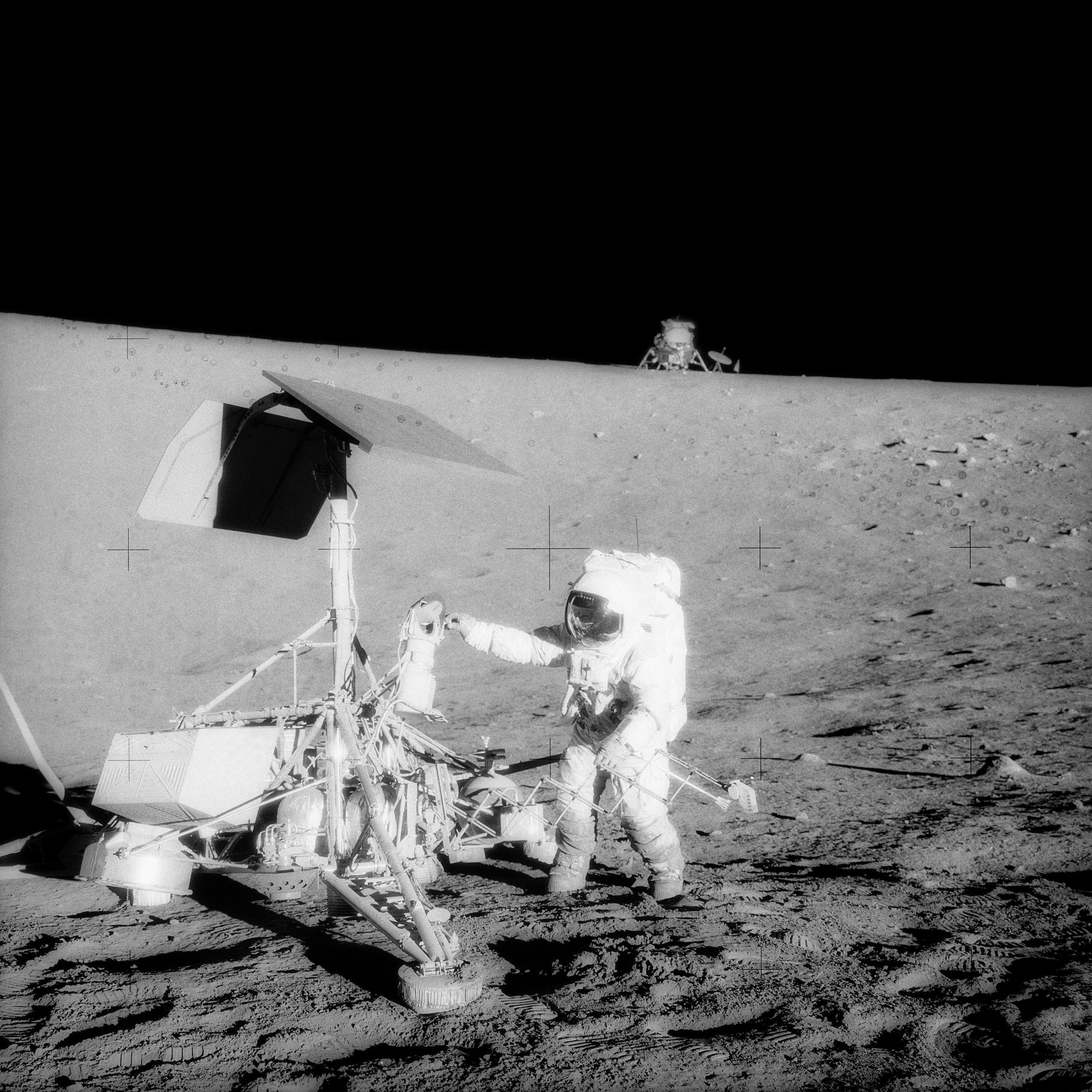 Al Bean photographed Pete Conrad at the Surveyor 3 spacecraft with the lunar module Intrepid on the horizon, November 20, 1969